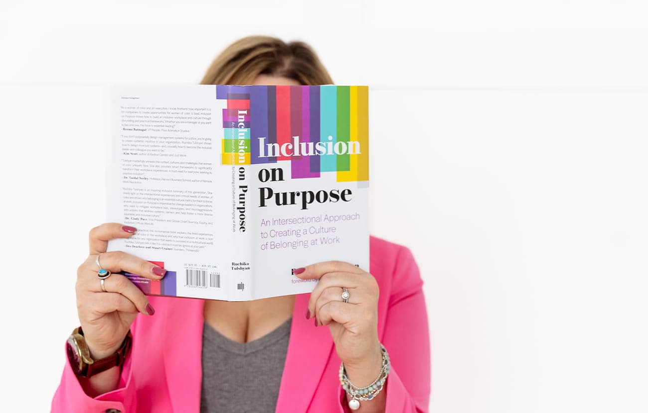 Matisse holding the book 'Inclusion on Purpose' in front of her face