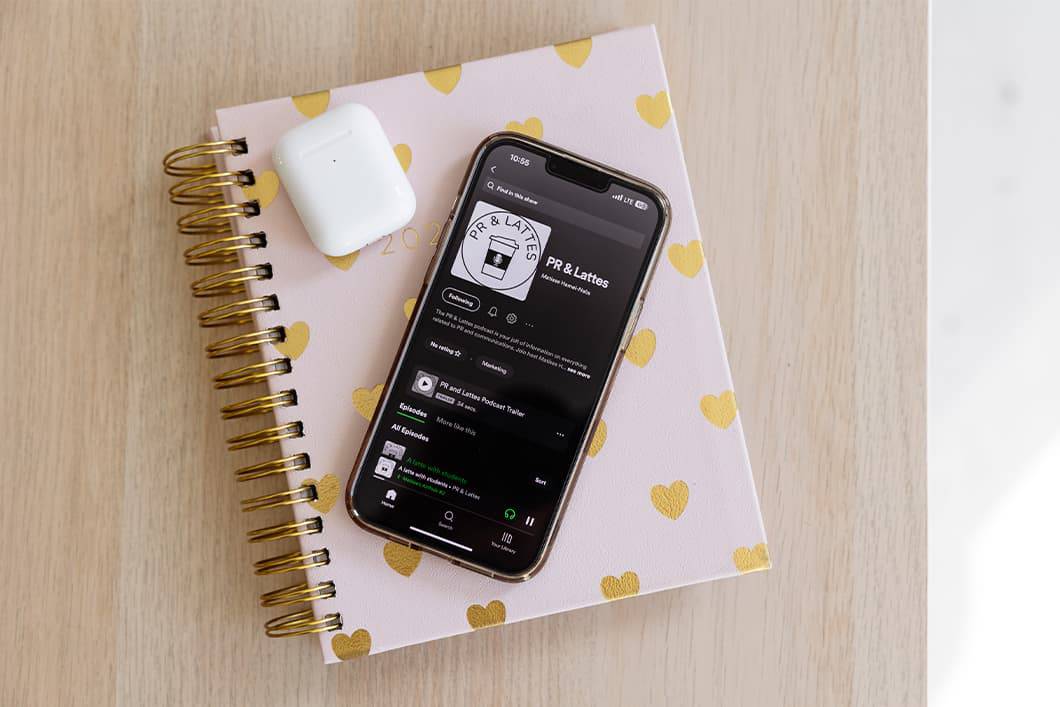 an iPhone and AirPods case atop a notebook