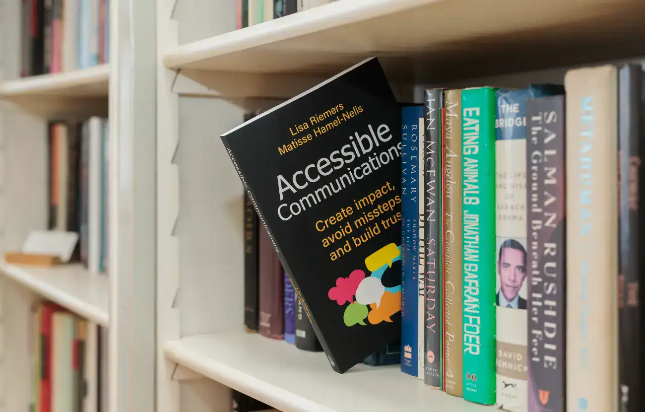 Matisse's book, Accessible Communications - Create impact, avoid missteps and build trust, co-written with Lisa Riemers, sticking out on a bookshelf.
